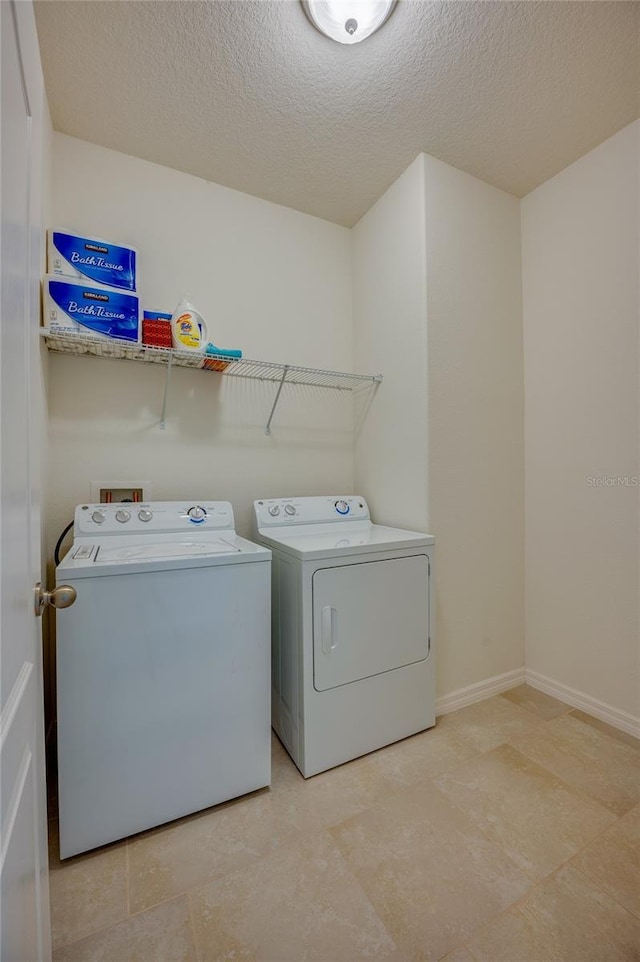 clothes washing area featuring a textured ceiling and independent washer and dryer