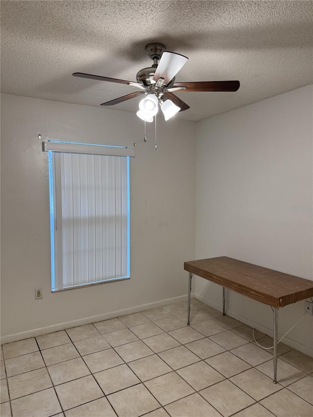 unfurnished room with ceiling fan, a textured ceiling, and light tile patterned flooring