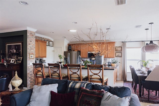 kitchen with stainless steel appliances, ornamental molding, hanging light fixtures, and tasteful backsplash