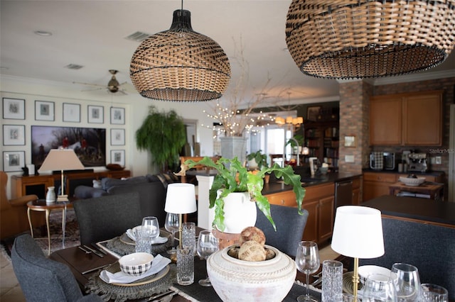 dining area featuring crown molding, ceiling fan, sink, and ornate columns