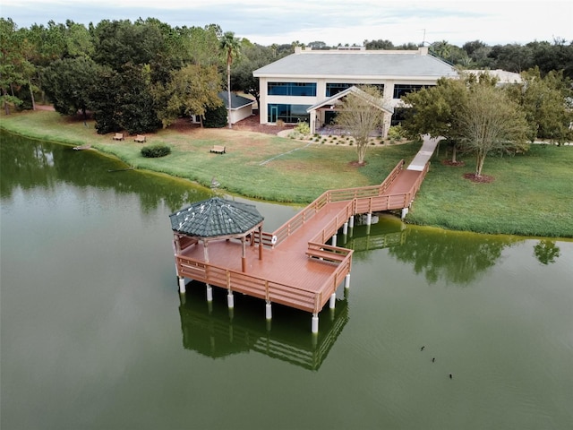 view of dock with a yard and a water view