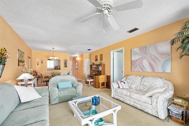 carpeted living room with a textured ceiling and ceiling fan with notable chandelier