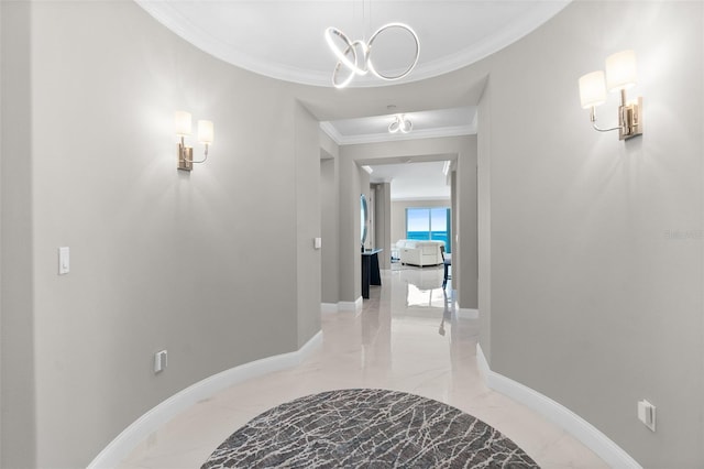 corridor with marble finish floor, a notable chandelier, baseboards, and crown molding