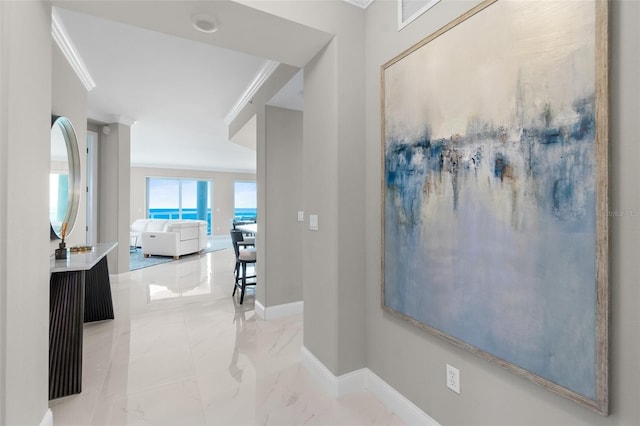 corridor with marble finish floor, baseboards, and ornamental molding