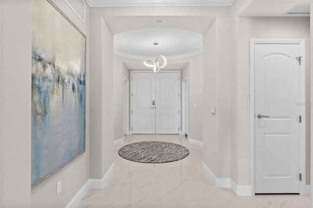 foyer entrance featuring marble finish floor, baseboards, arched walkways, and crown molding