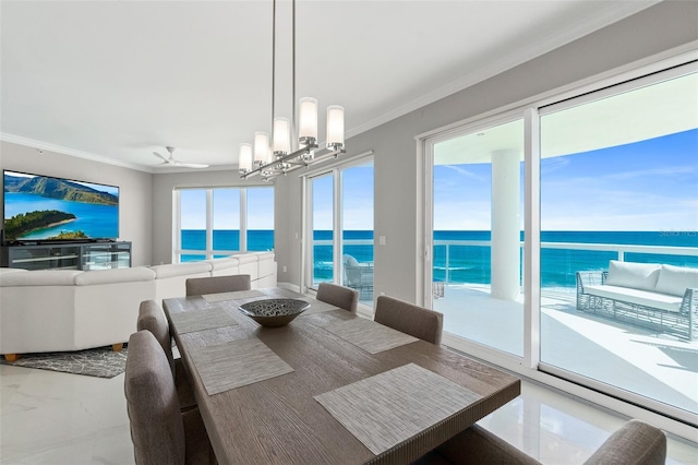 dining space with ceiling fan with notable chandelier, ornamental molding, and a water view