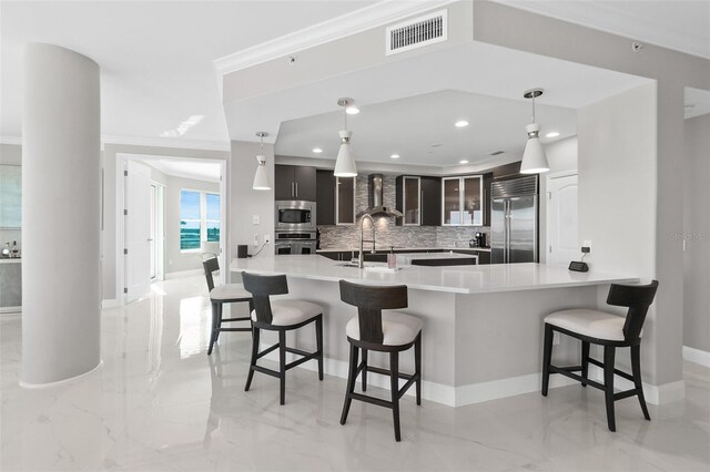 kitchen featuring built in appliances, wall chimney exhaust hood, visible vents, and marble finish floor