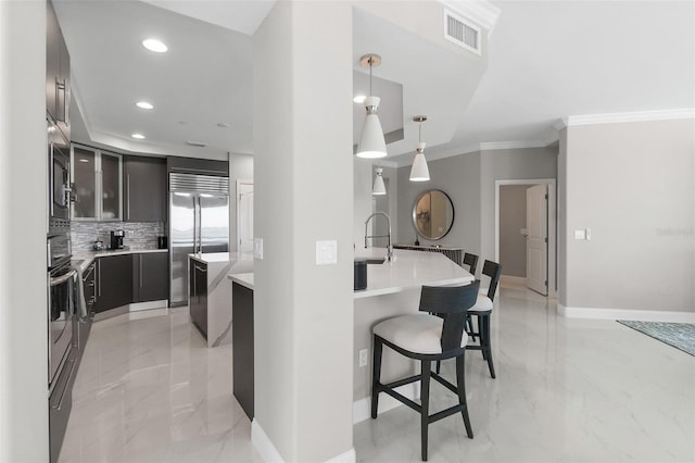 kitchen with marble finish floor, visible vents, a kitchen bar, and built in appliances