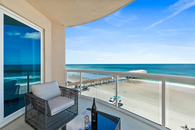 balcony featuring a water view and a view of the beach