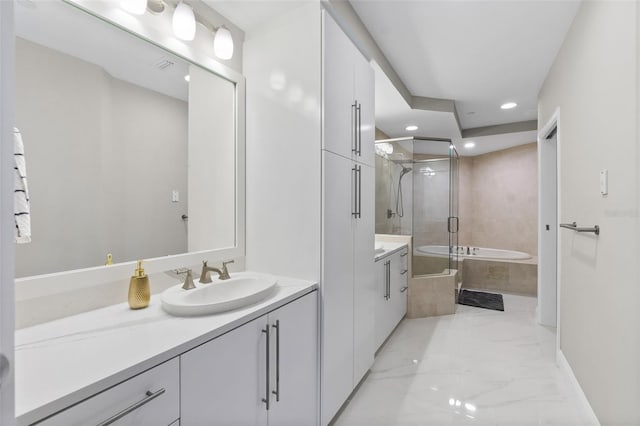 bathroom with a stall shower, marble finish floor, a garden tub, vanity, and recessed lighting