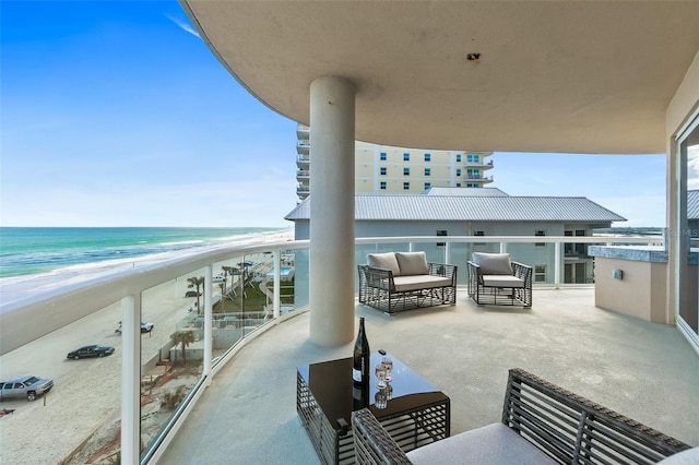 balcony featuring a water view and a view of the beach