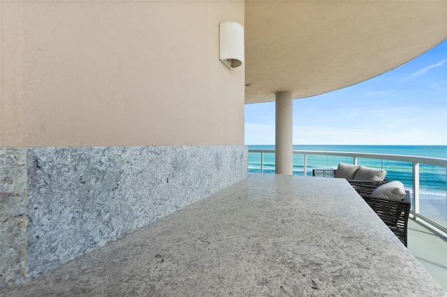 balcony with a water view and outdoor dining area