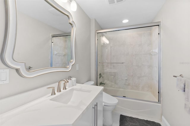 bathroom with toilet, enclosed tub / shower combo, and vanity