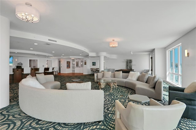 carpeted living room featuring recessed lighting, visible vents, and ornate columns