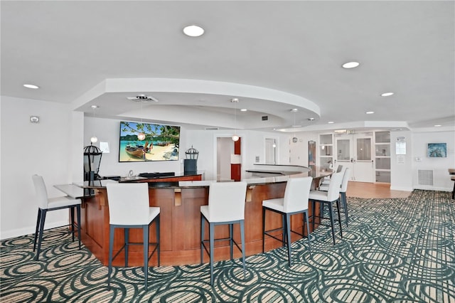 kitchen with recessed lighting, visible vents, and a kitchen bar