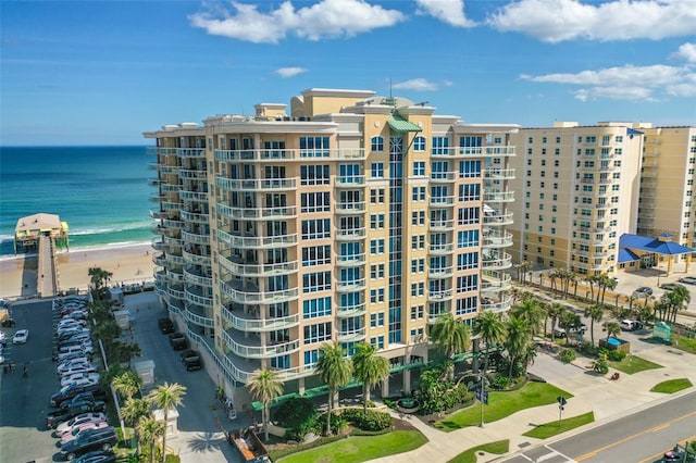 view of property with a water view and a beach view