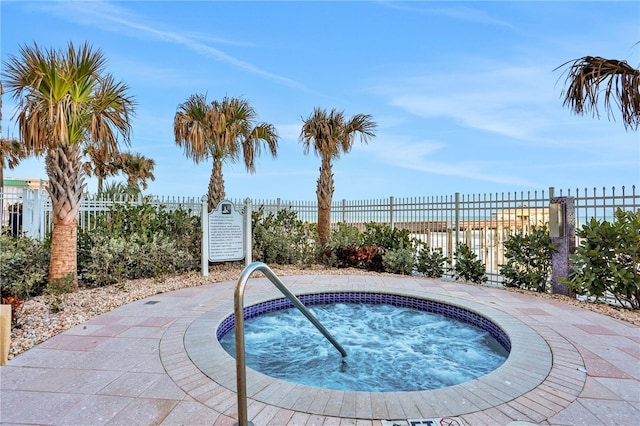 view of swimming pool with a community hot tub and fence