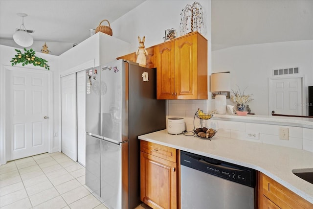 kitchen featuring stainless steel appliances, brown cabinetry, light countertops, and visible vents