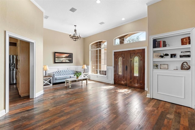 entrance foyer featuring crown molding, dark hardwood / wood-style floors, and an inviting chandelier