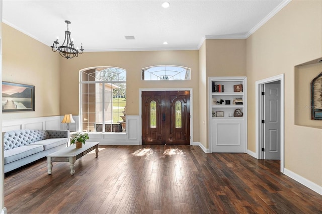 entryway with dark hardwood / wood-style flooring, a chandelier, and crown molding