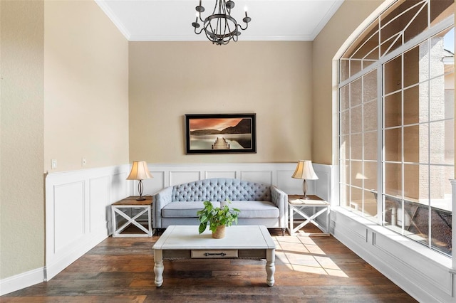 living room featuring dark wood-type flooring, crown molding, an inviting chandelier, and a wealth of natural light