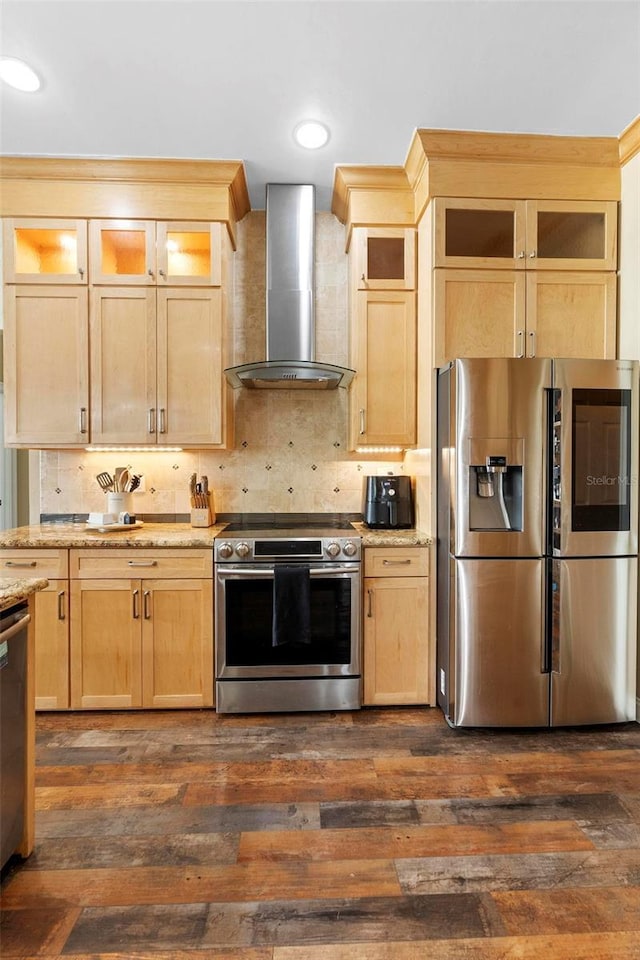 kitchen with stainless steel appliances, wall chimney exhaust hood, and light brown cabinetry