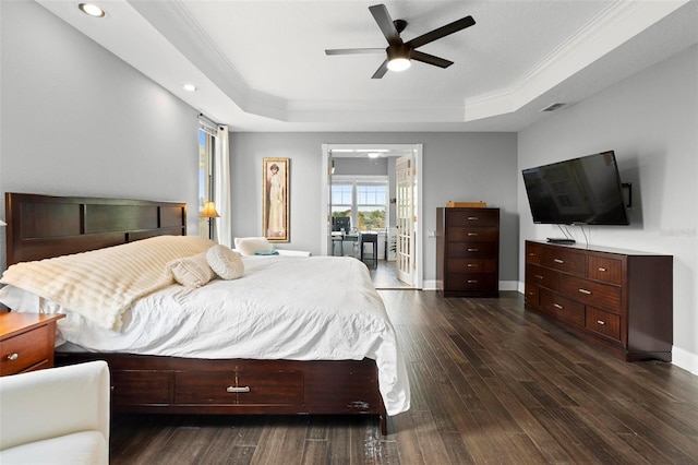 bedroom with a raised ceiling, crown molding, dark wood-type flooring, and ceiling fan