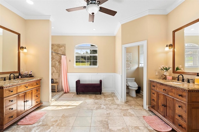 bathroom featuring toilet, ceiling fan, vanity, crown molding, and a shower with shower curtain