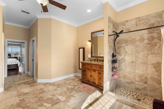 bathroom featuring ceiling fan, ornamental molding, vanity, and a tile shower