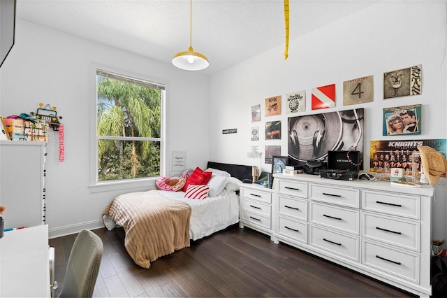 bedroom featuring a textured ceiling and dark hardwood / wood-style floors