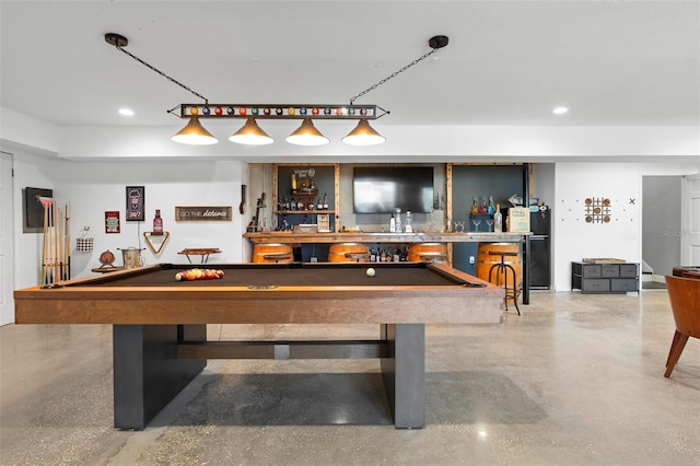 game room featuring pool table, concrete flooring, and bar