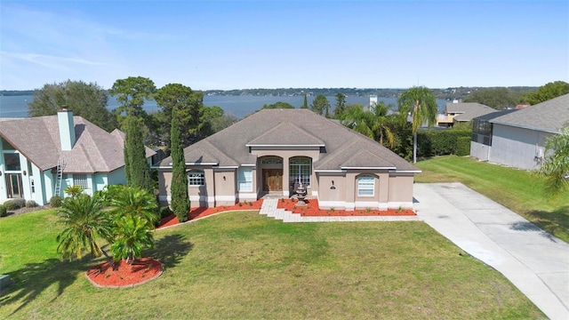 view of front of house featuring a front lawn and a water view