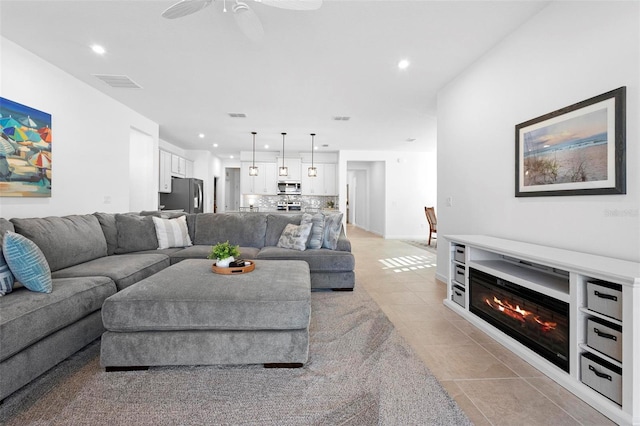 living room with ceiling fan and light tile patterned floors