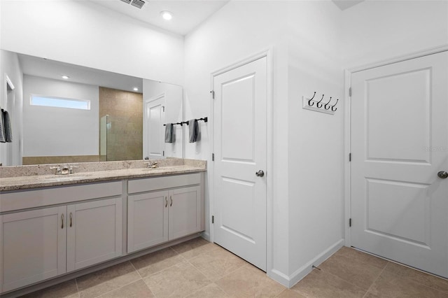 bathroom with tile patterned flooring, an enclosed shower, and vanity