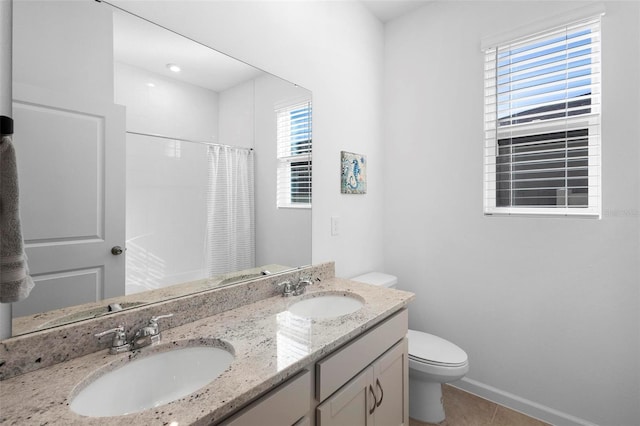 bathroom with tile patterned floors, toilet, vanity, and walk in shower