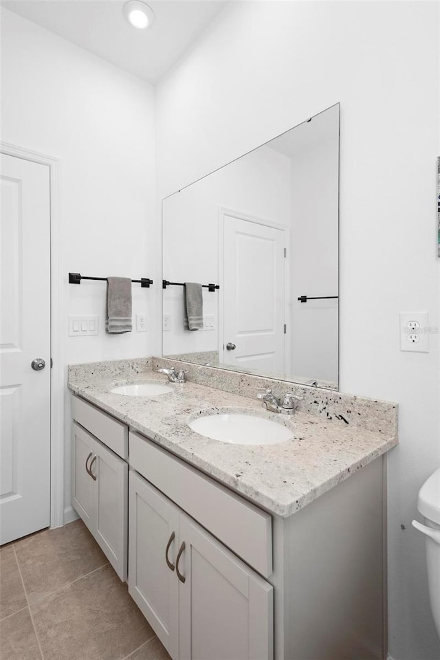 bathroom with vanity, toilet, and tile patterned floors