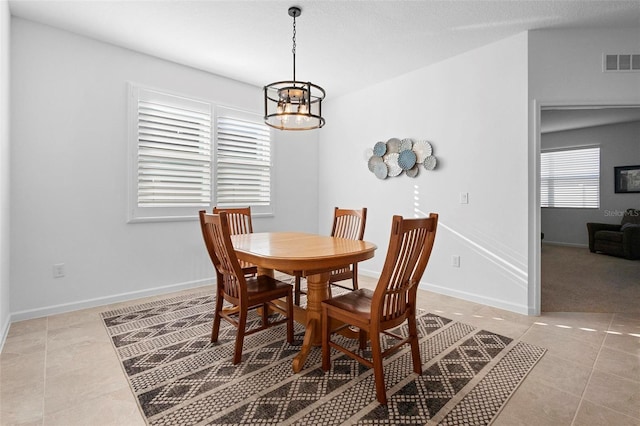 tiled dining space with a chandelier