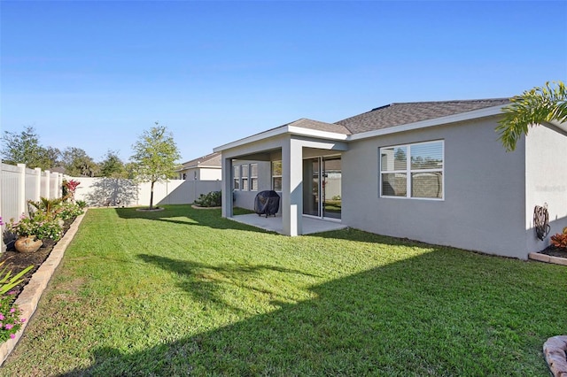 back of property with a yard and a patio area