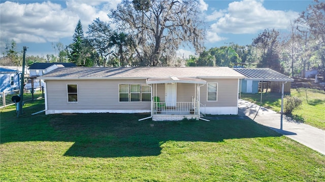 manufactured / mobile home featuring a carport, a front lawn, and concrete driveway