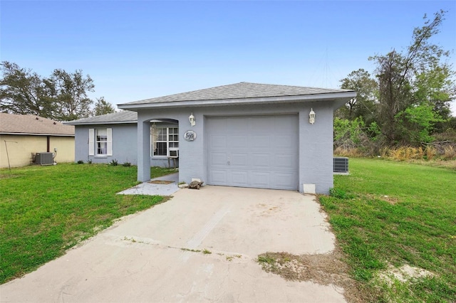 view of front of house with central air condition unit, an attached garage, concrete driveway, and a front yard