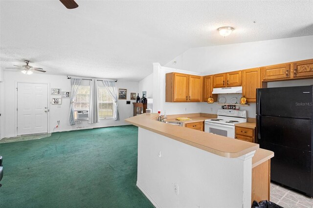 kitchen featuring electric stove, light countertops, freestanding refrigerator, a peninsula, and under cabinet range hood