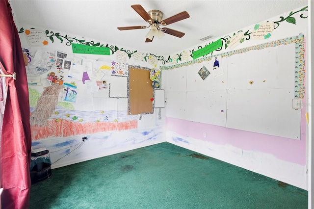 unfurnished room featuring visible vents, dark carpet, and ceiling fan