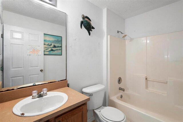 full bath featuring a textured ceiling, toilet, vanity, and washtub / shower combination