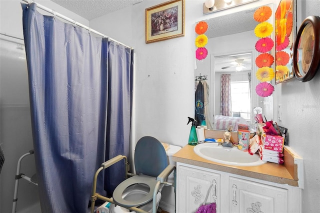 full bathroom with a shower with shower curtain, ceiling fan, a textured ceiling, and vanity