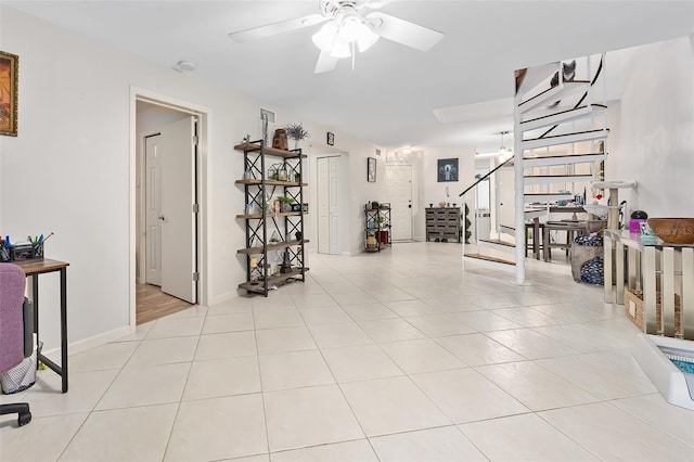 exercise room featuring ceiling fan and light tile patterned floors