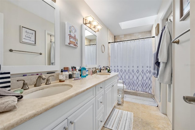 bathroom with vanity, toilet, a skylight, and walk in shower