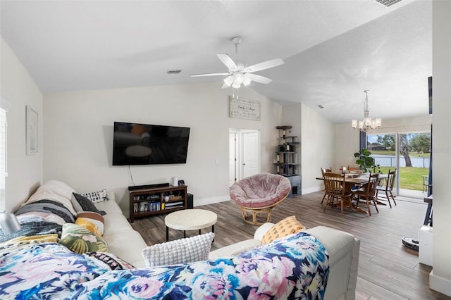 living room with ceiling fan with notable chandelier, lofted ceiling, and wood-type flooring