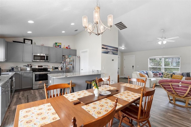 dining room with ceiling fan with notable chandelier, high vaulted ceiling, dark hardwood / wood-style flooring, and sink