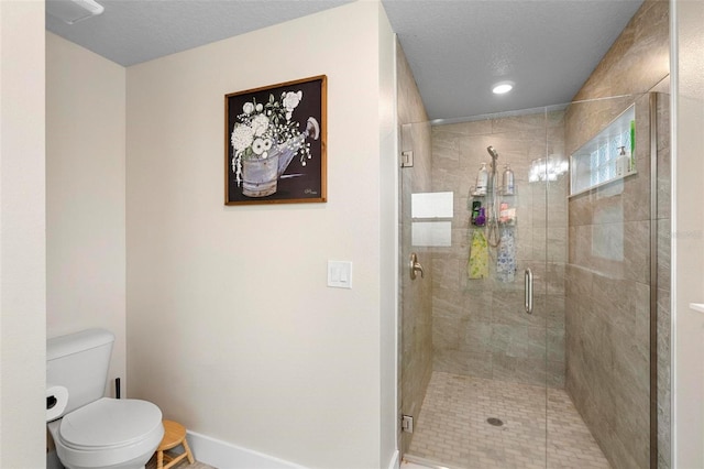 bathroom with a textured ceiling, toilet, and a shower with door