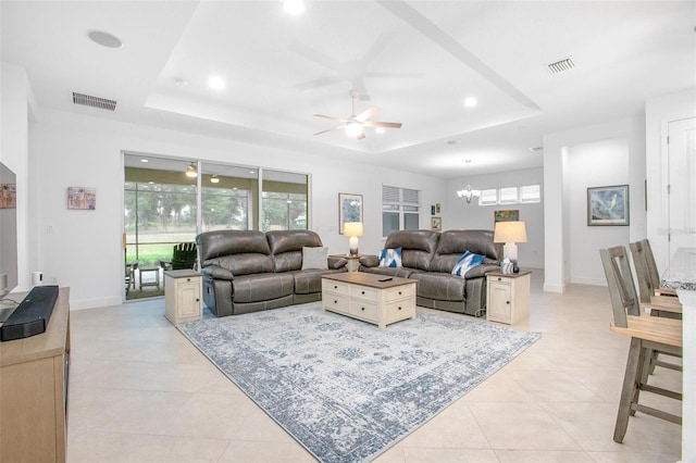 living room with light tile patterned floors, a tray ceiling, visible vents, and recessed lighting